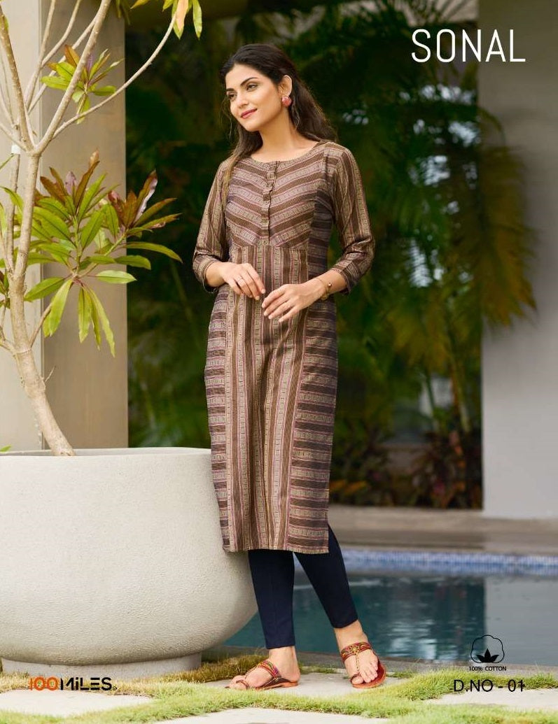 Woman in a patterned dress standing by a pool with plants in the background | 100 MILES SONAL 01 TO 04 SERIES FANCY COTTON BLEND EMBROIDERY KURTIS