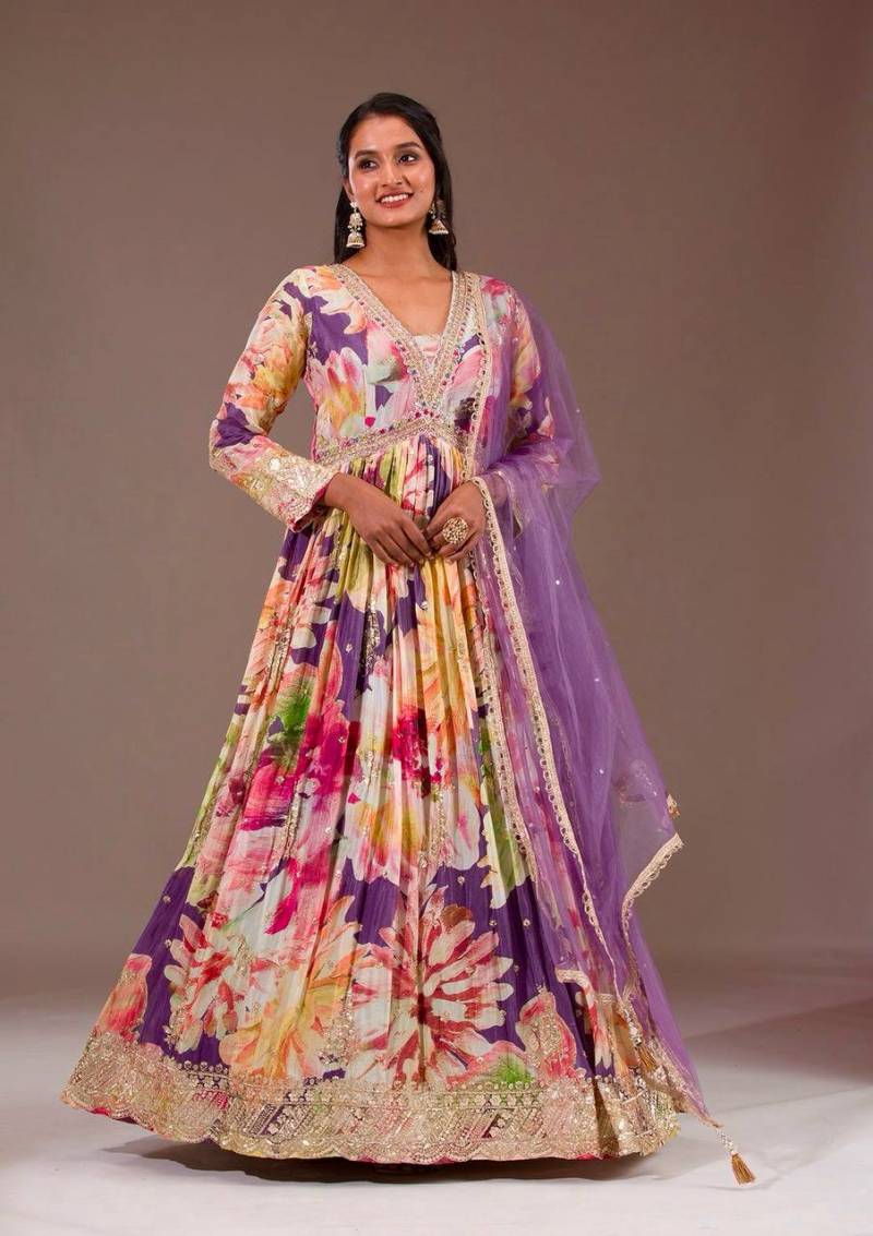 Woman wearing a colorful traditional outfit with a floral pattern on a plain background | 5012 Beautiful Star Georgette Embroidery Floral Worked Anarkali Kurti Collection