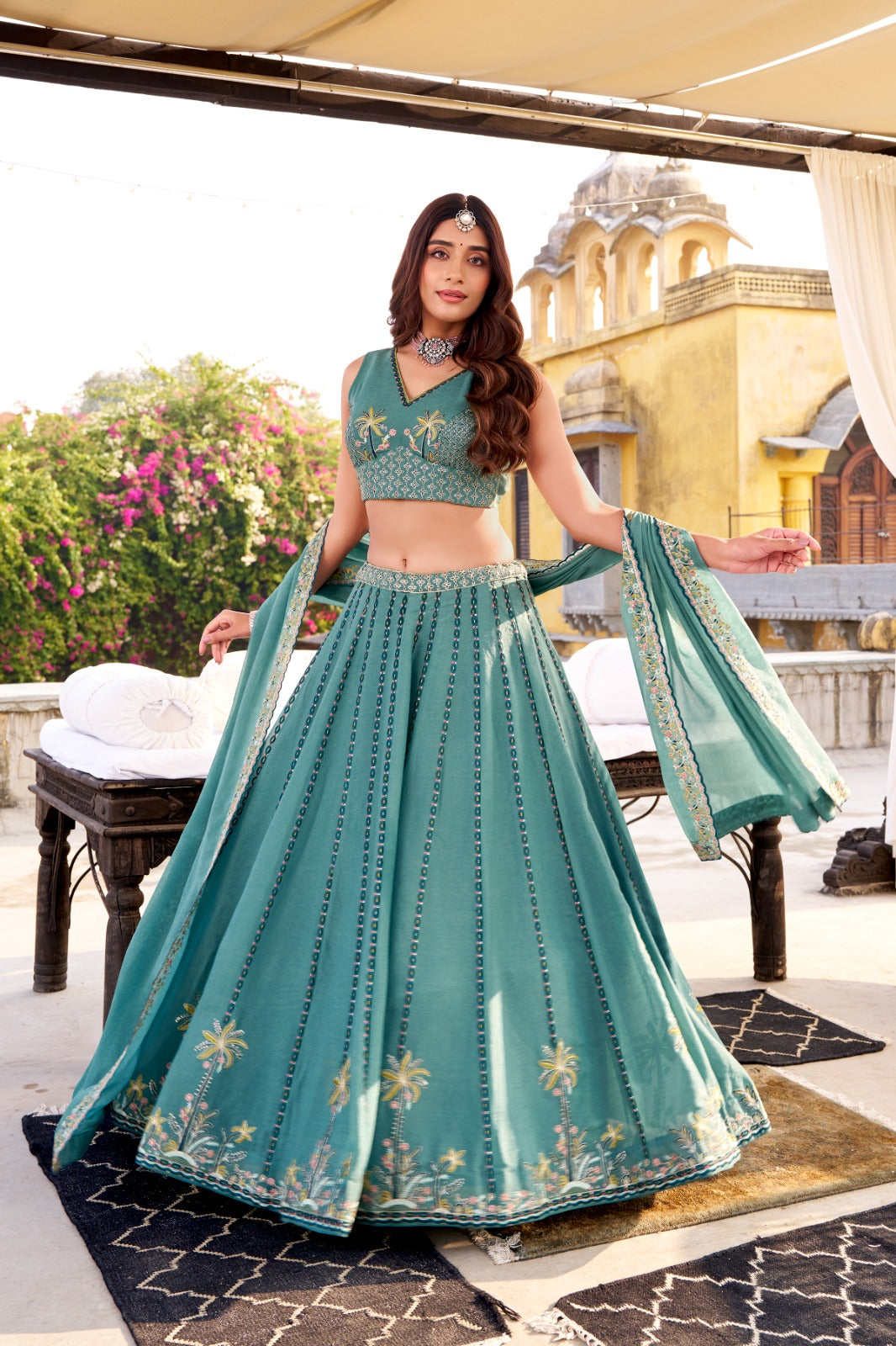 Woman in a teal embroidered lehenga standing on a rooftop with a scenic background | Taraa L 1457 Chocolate Crush Embroidery Worked Beautiful Lehenga Choli Collection