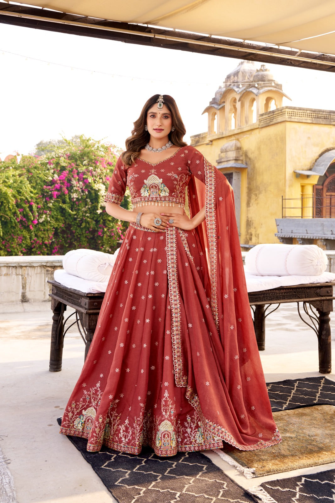 Woman in a red traditional outfit with intricate designs standing outdoors. | Taraa L 1457 Chocolate Crush Embroidery Worked Beautiful Lehenga Choli Collection