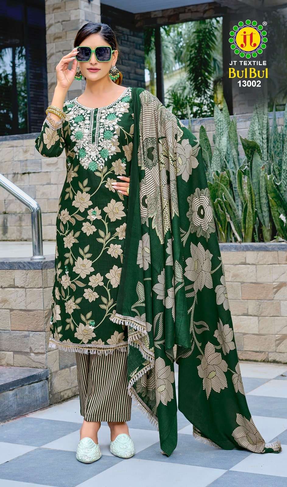 Woman wearing a green embroidered outfit with a brand logo in the corner.