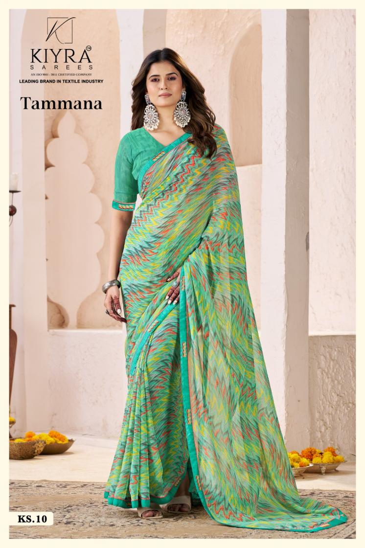 Woman wearing a green saree with a pattern, standing against a neutral background with 'Kiyra' branding. | Kiyra Presents Tammana Georgette Fancy Sarees