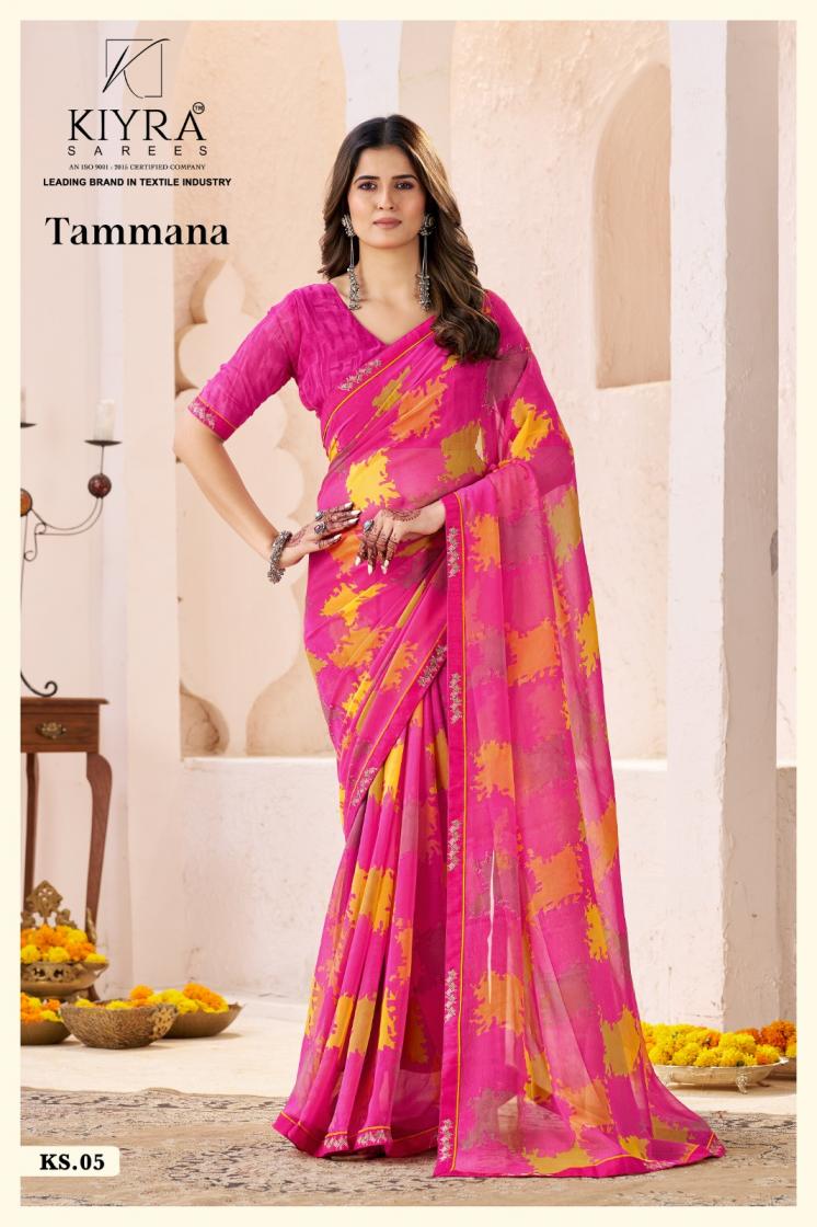 Woman wearing a pink saree with yellow patterns, standing indoors. | Kiyra Presents Tammana Georgette Fancy Sarees