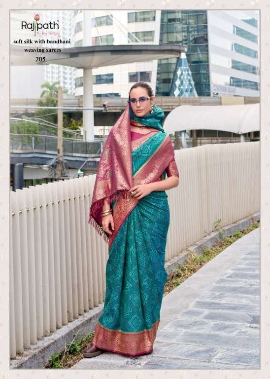 Woman wearing a green and pink saree with a cityscape background | RAJPATH Sugandh Silk Pure Silk Bandhani Sarees Catalogue