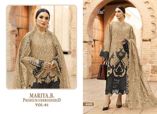 Woman wearing a beige embroidered outfit with black patterns in an outdoor setting. | SHREE FAB MARIA B VOL-01 Pure Cotton Embroidered Pakistani Dresses Wholesale