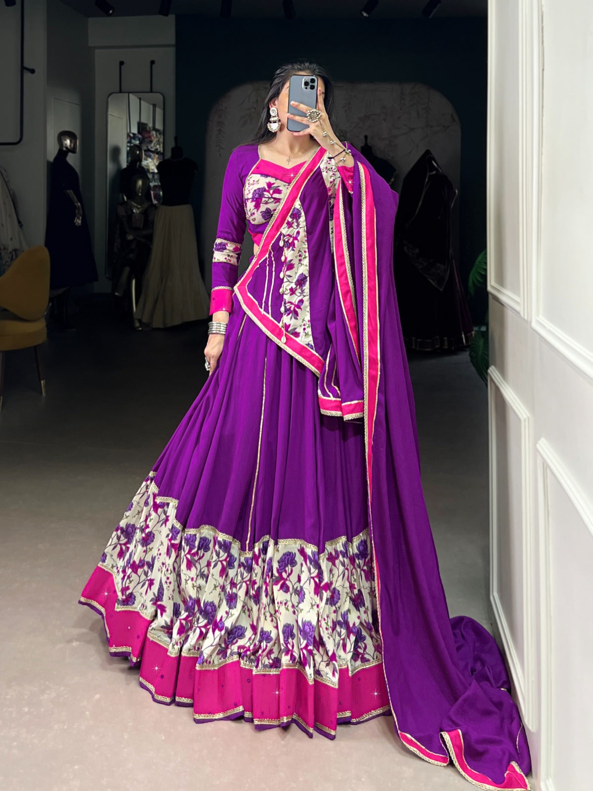 Person wearing a purple traditional outfit with floral patterns in a room. | Taraa L 1618 Rayon Original Mirror Handworked Beautiful Lehenga Choli Collection