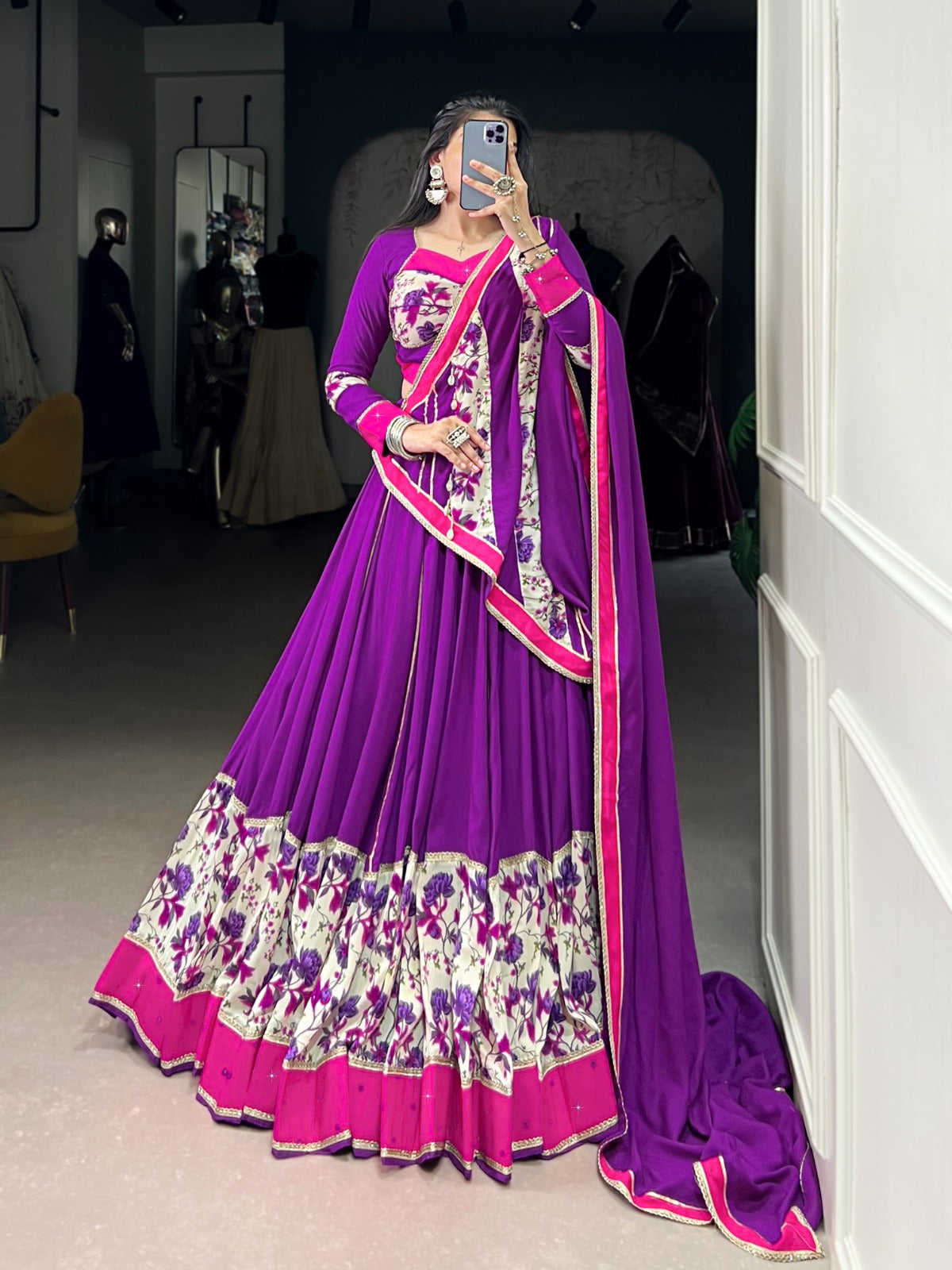 Woman taking a mirror selfie wearing a purple and pink traditional outfit with floral patterns. | Taraa L 1618 Rayon Original Mirror Handworked Beautiful Lehenga Choli Collection