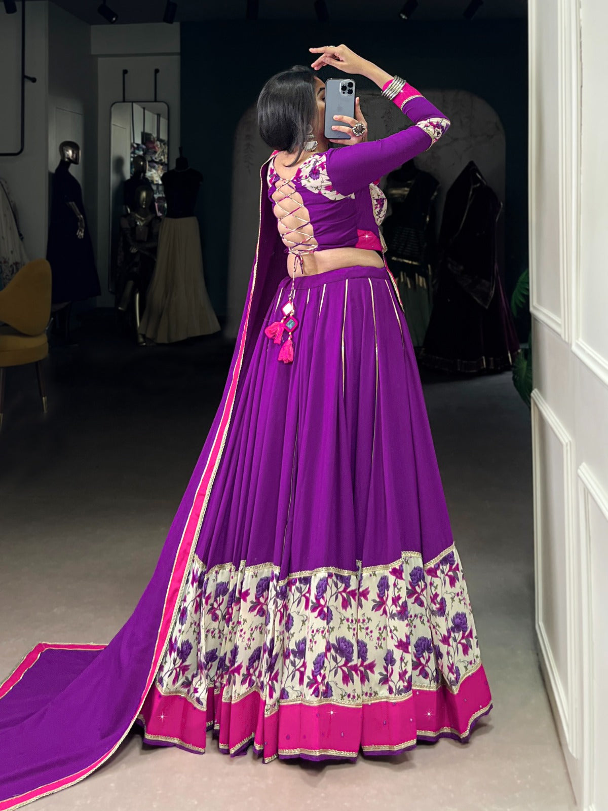 Woman taking a mirror selfie wearing a purple and pink traditional outfit with floral patterns. | Taraa L 1618 Rayon Original Mirror Handworked Beautiful Lehenga Choli Collection