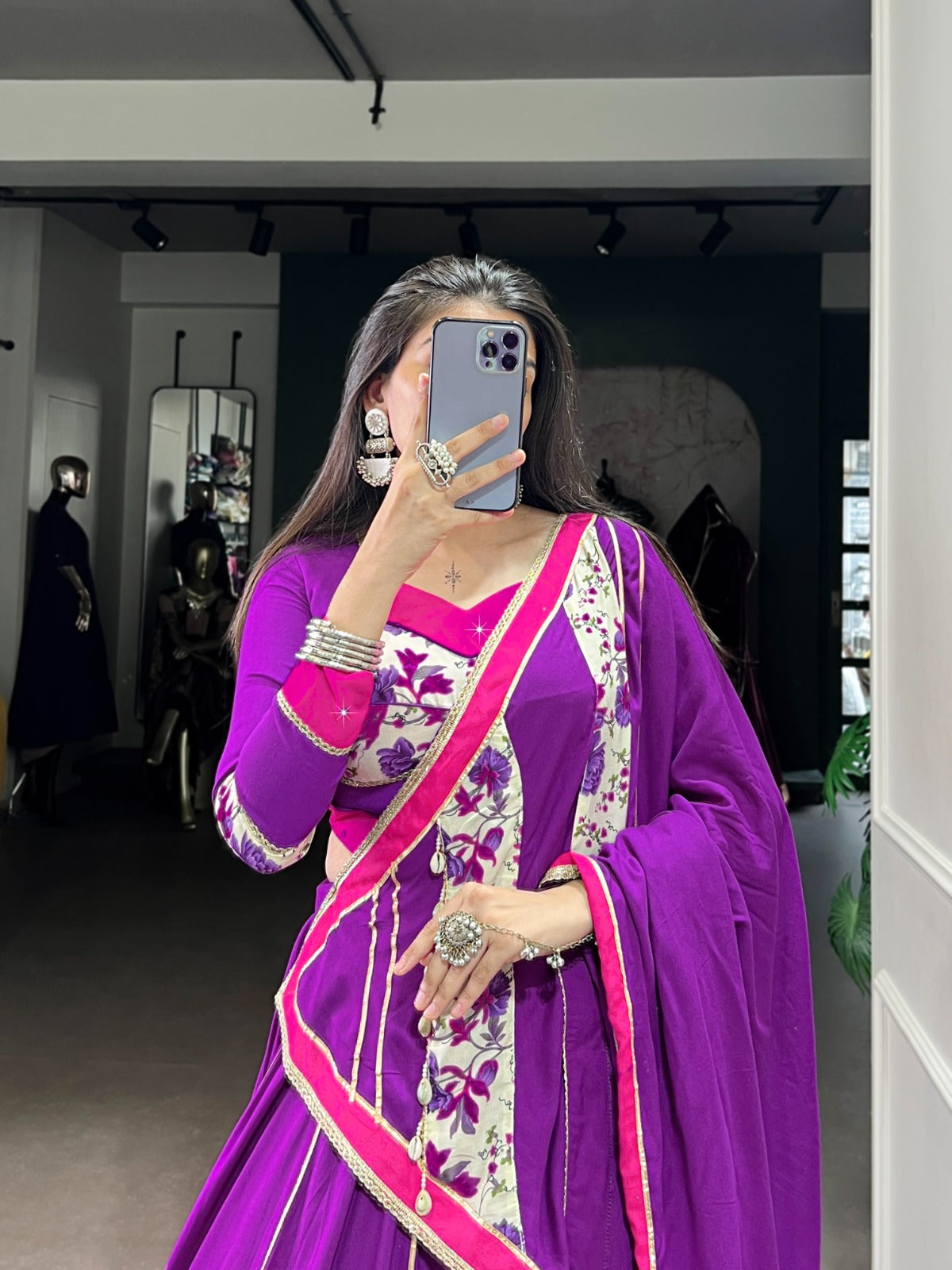 Person wearing a purple saree with floral patterns in a room. | Taraa L 1618 Rayon Original Mirror Handworked Beautiful Lehenga Choli Collection