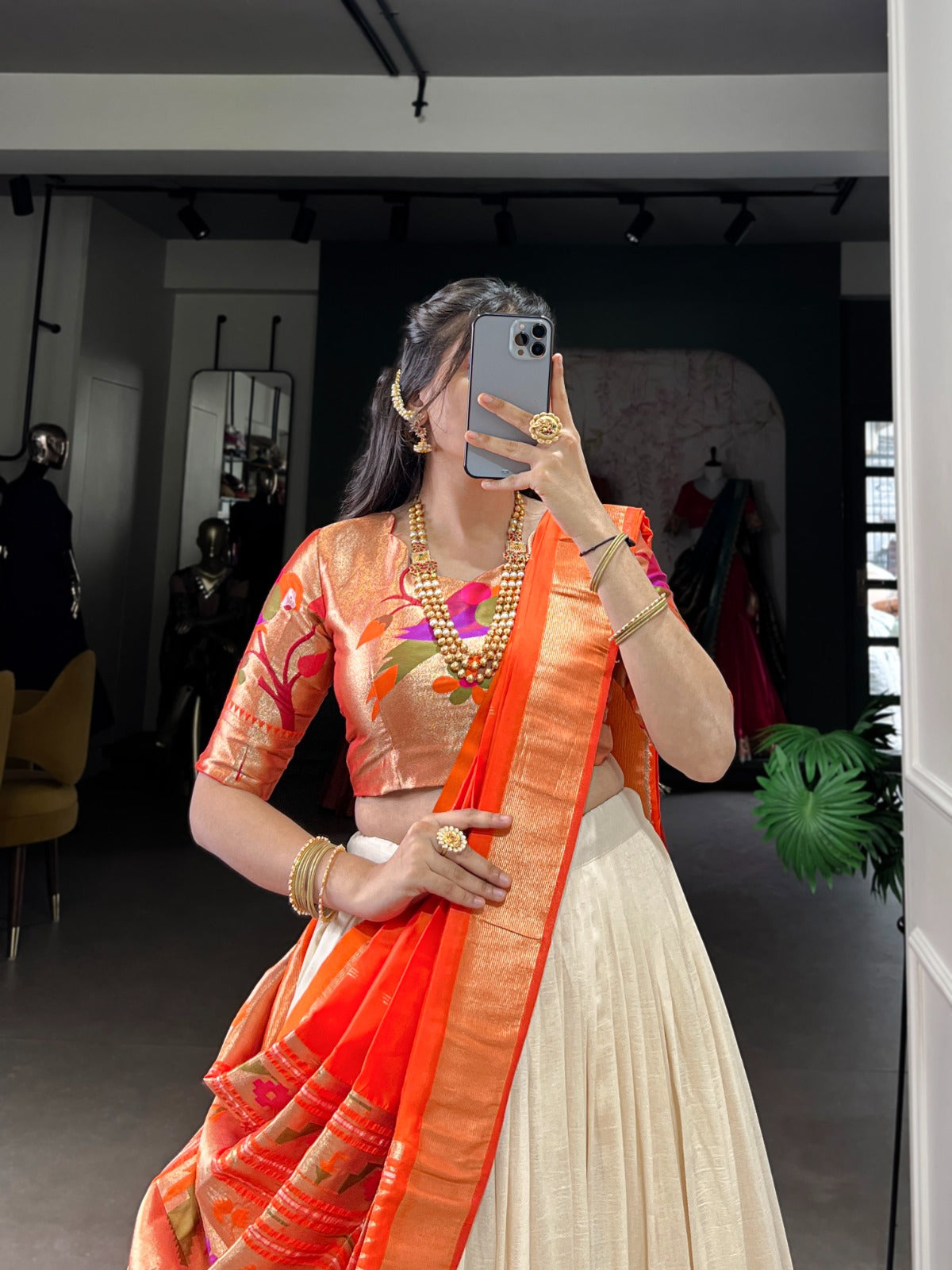 Woman taking a mirror selfie wearing an orange saree with a white blouse. | Taraa L 2007 Vichitra Silk Zari Weaving Plain Lehenga Choli Collection