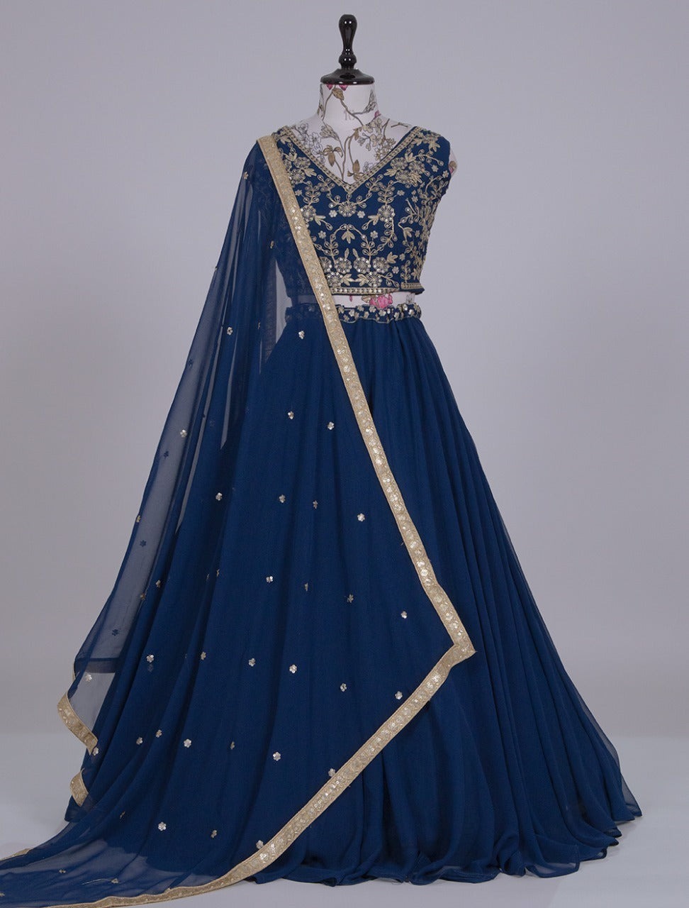 Navy blue embroidered dress with gold details on a mannequin against a gray background | V3 366 Faux Georgette Embroidered Designer Lehenga Choli Wholesale Price